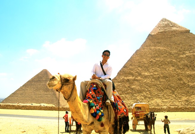 on a camel with the Pyramids of Khufu and Khafre shown